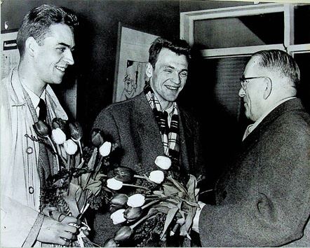 John McCarry byder Jørgen Hammergaard Hansen (tv) og Finn Kobberø velkommen til Glasgow til invitationsturneringen, der i en årrække blev holdt i forbindelse med All England, ca. 1960. Her udnyttede den senere præsident for IBF, David Bloomer, at Østens bedste spillere var i Europa.